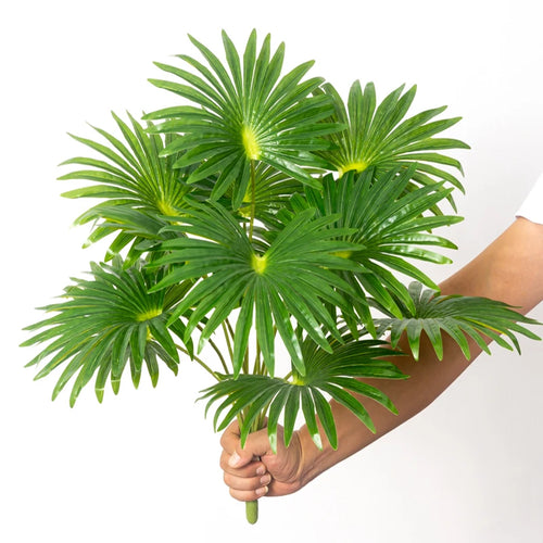 Artificial tropical monstera and palm palm plants in plastic for decoration