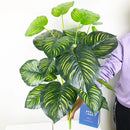 Artificial monstera and palm tropical leaves for indoor decoration