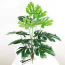 Artificial monstera and palm tropical leaves for indoor decoration