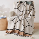 Bohemian striped knit throw with geometric pattern and pompom trim