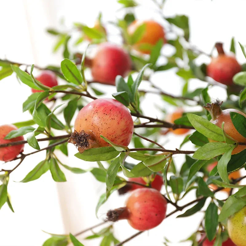 Garden decoration with artificial pomegranates and green plants