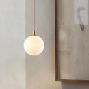 Minimalist brass pendant light with milky glass orb