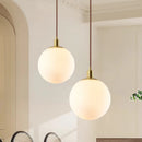 Minimalist brass pendant light with milky glass orb