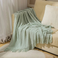 Nordic-style knitted throw with pom-poms and check pattern
