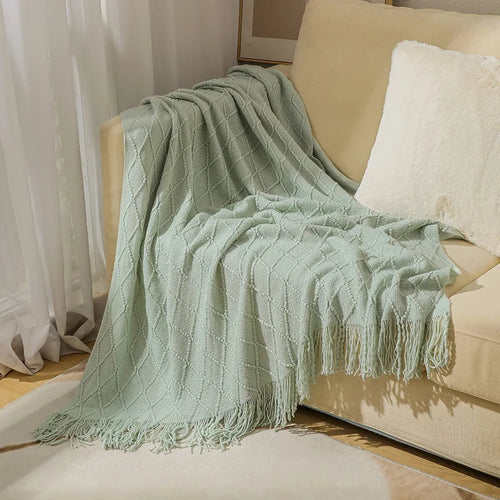 Nordic-style knitted throw with pom-poms and check pattern