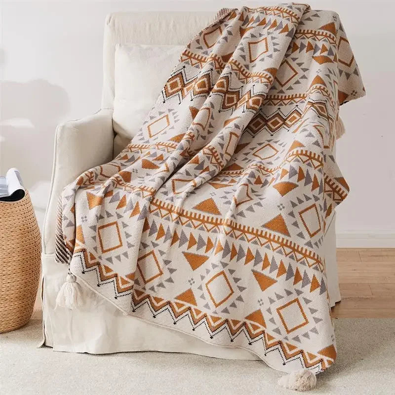 Knitted boho-style geometric throw with pompoms