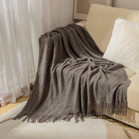 Soft knitted plaid with pom-poms, chequered style for sofa or bed