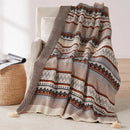 Bohemian striped knit throw with geometric pattern and pompom trim