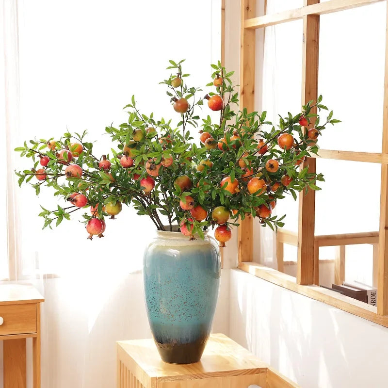 Garden decoration with artificial pomegranates and green plants