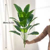 Large artificial tropical palm tree with banana and strelitzia leaves