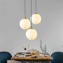 Modern minimalist brass pendant light with luminous orb