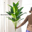 Large artificial tropical palm tree with banana and strelitzia leaves