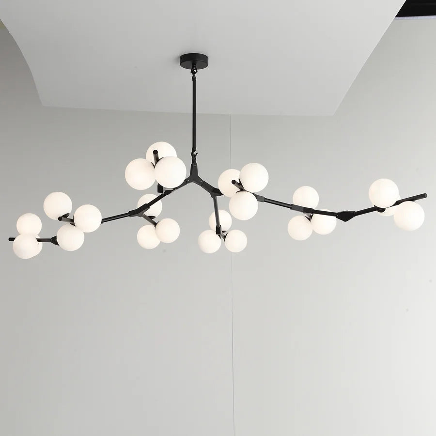 Glass chandelier with tree branches and glowing glass balls
