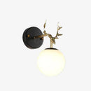 Gold antler wall light with glass globe