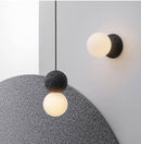Designer wall light with cement and glass globe