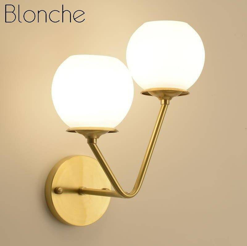 Designer LED wall light in gold metal with double glass ball