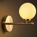 Gold wall light with one or two glass globes