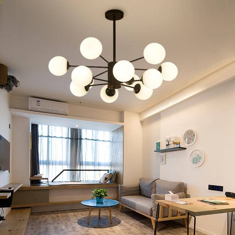 Black designer chandelier with multiple arms and vintage glass lamps