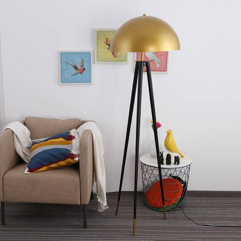 Designer floor lamp with three-legged base and spherical gold metal shade