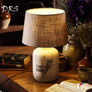 Bedside lamp with fabric shade and deer design