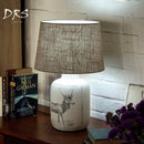 Bedside lamp with fabric shade and deer design