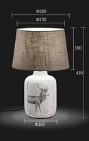 Bedside lamp with fabric shade and deer design