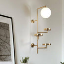 Modern LED wall light with multiple gold discs and glass sphere