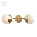 Gold wall light with glass globe arm bean