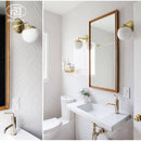 Gold wall light with glass globe arm bean